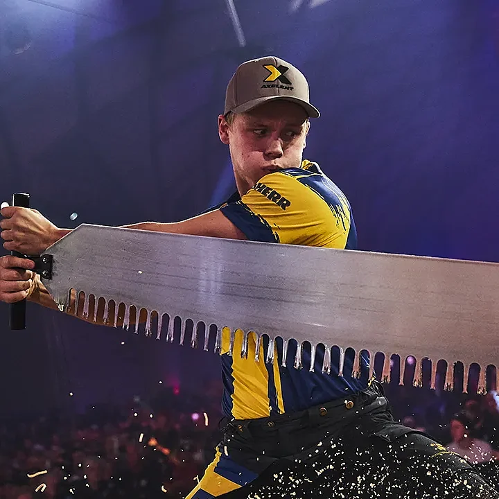Professional STIHL TIMBERSPORTS athlete performing a competitive crosscut saw event on stage in front of a live audience.